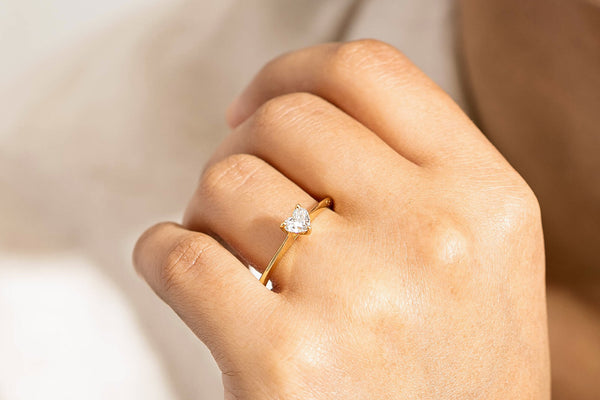 Close up of model wearing diamond heart shaped solitaire ring