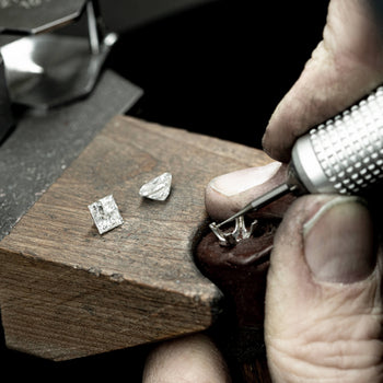 Jeweller setting a diamond into a ring