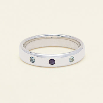 Sterling Silver Milestone band set with blue topaz, sapphire and aquamarine gemstones on a neutral background.