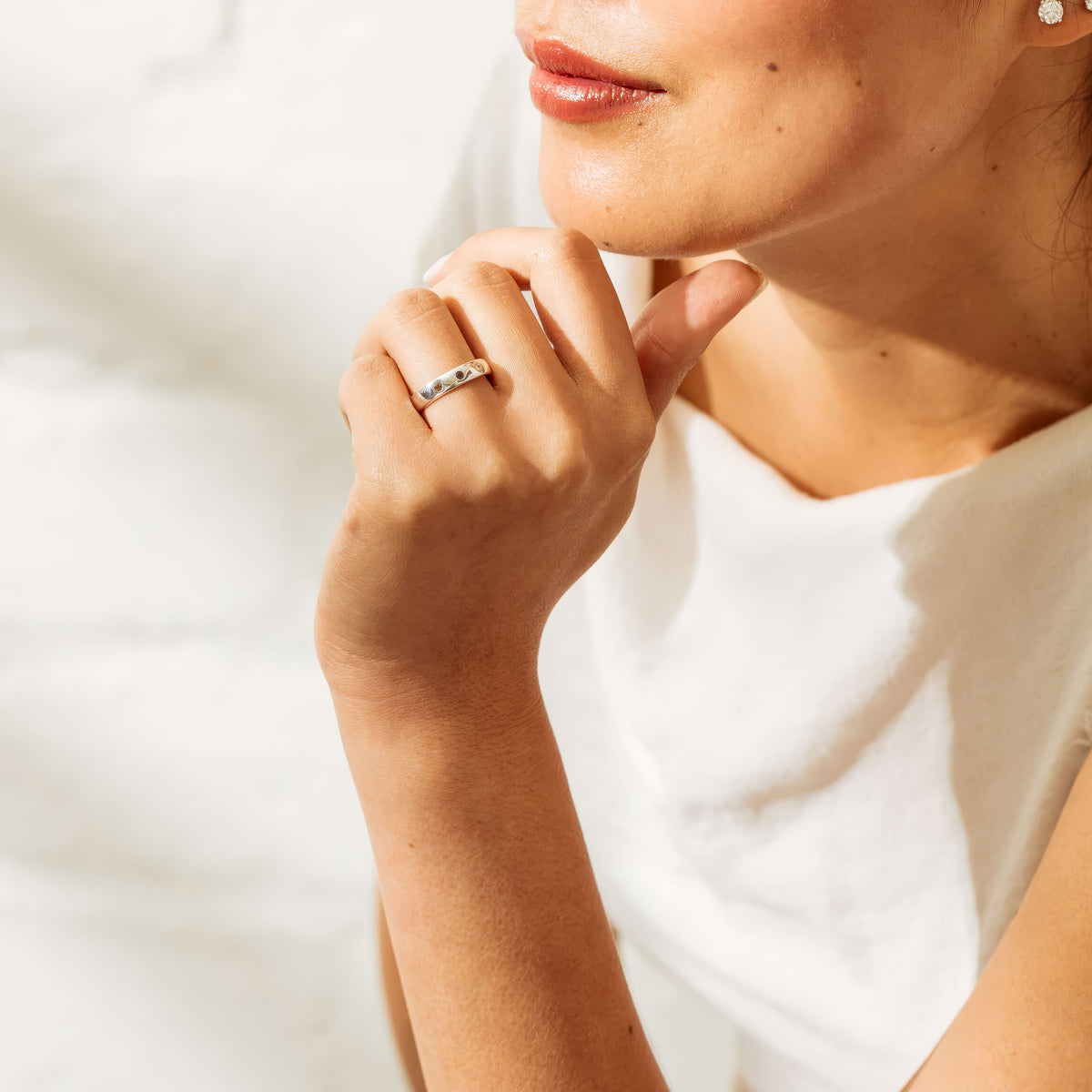 Close up of model wearing white top and Sterling Silver Milestone Band