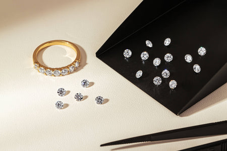 Panorama diamond band and loose round brilliant cut diamonds resting on neutral background