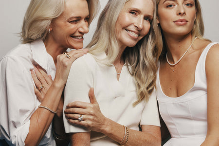 Three generations of women sitting next to one another wearing pearl and diamond jewellery