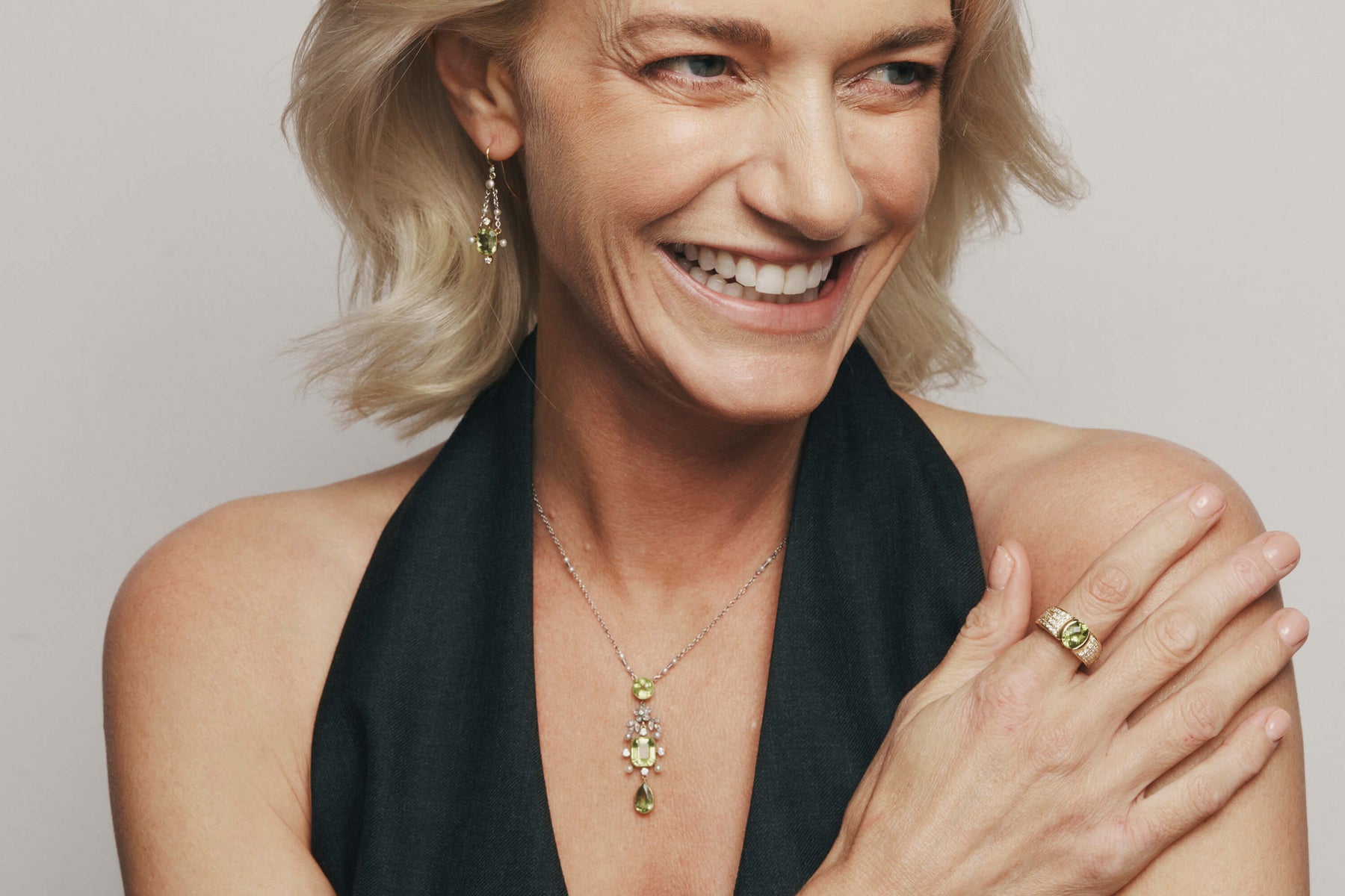 Close up of model smiling wearing Vintage gold and peridot jewellery