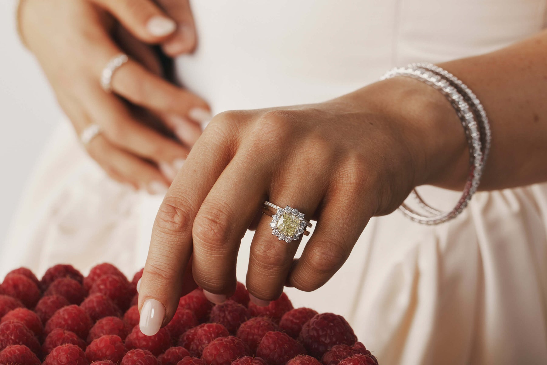Close up of a bride's hand wearing a cushion cut yellow diamond ring